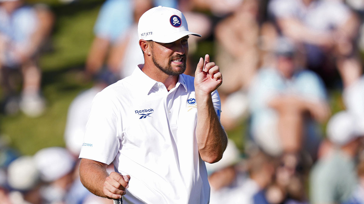 Bryson DeChambeau gestures to his caddie on the 18th green during the third round of the PGA Championship golf tournament at Quail Hollow.