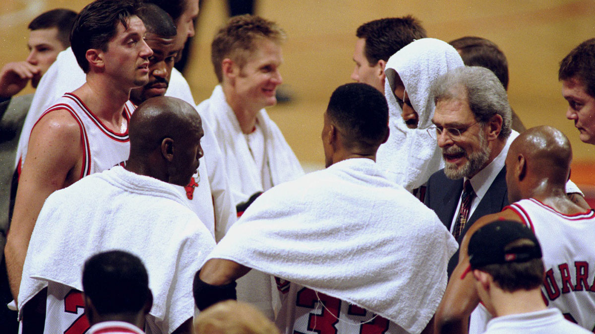 Chicago Bulls coach Phil Jackson, right, with team (clockwise from Phil) Scott Burrell (24), Scottie Pippen (33), Michael Jordan (23), Toni Kukoc (7), Dickey Simpkins (8), Steve Kerr (25) and Dennis Rodman (91) during a game against the Detroit Pistons at the United Center.