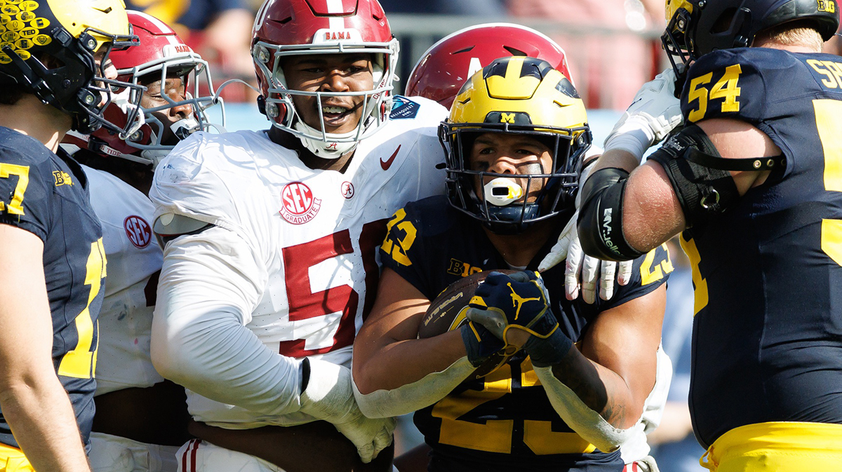 Alabama Crimson Tide defensive lineman Tim Smith (50) and Michigan Wolverines running back Jordan Marshall (23) smile after a stop during the second half at Raymond James Stadium.