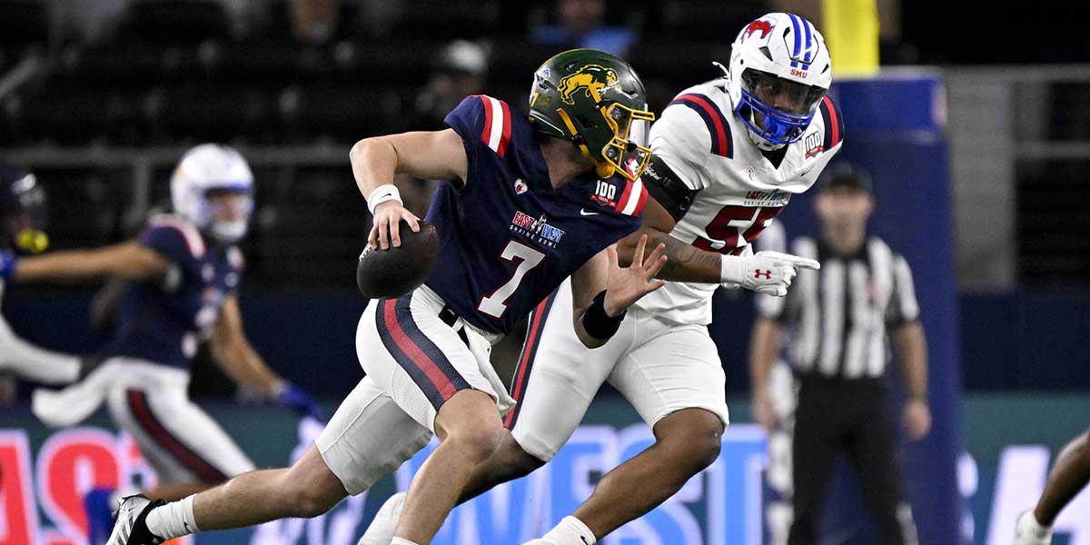 East quarterback Cam Miller of North Dakota State (7) rolls out to avoid the rush of West edge rusher Elijah Roberts of SMU (55) during the first half at AT&T Stadium.