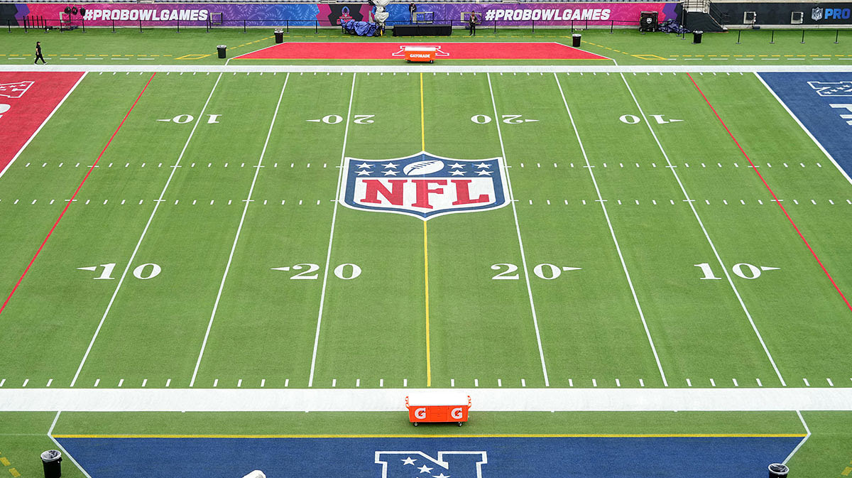 An overall view of the NFL shield logo at midfield on the Camping World Stadium flag football field.