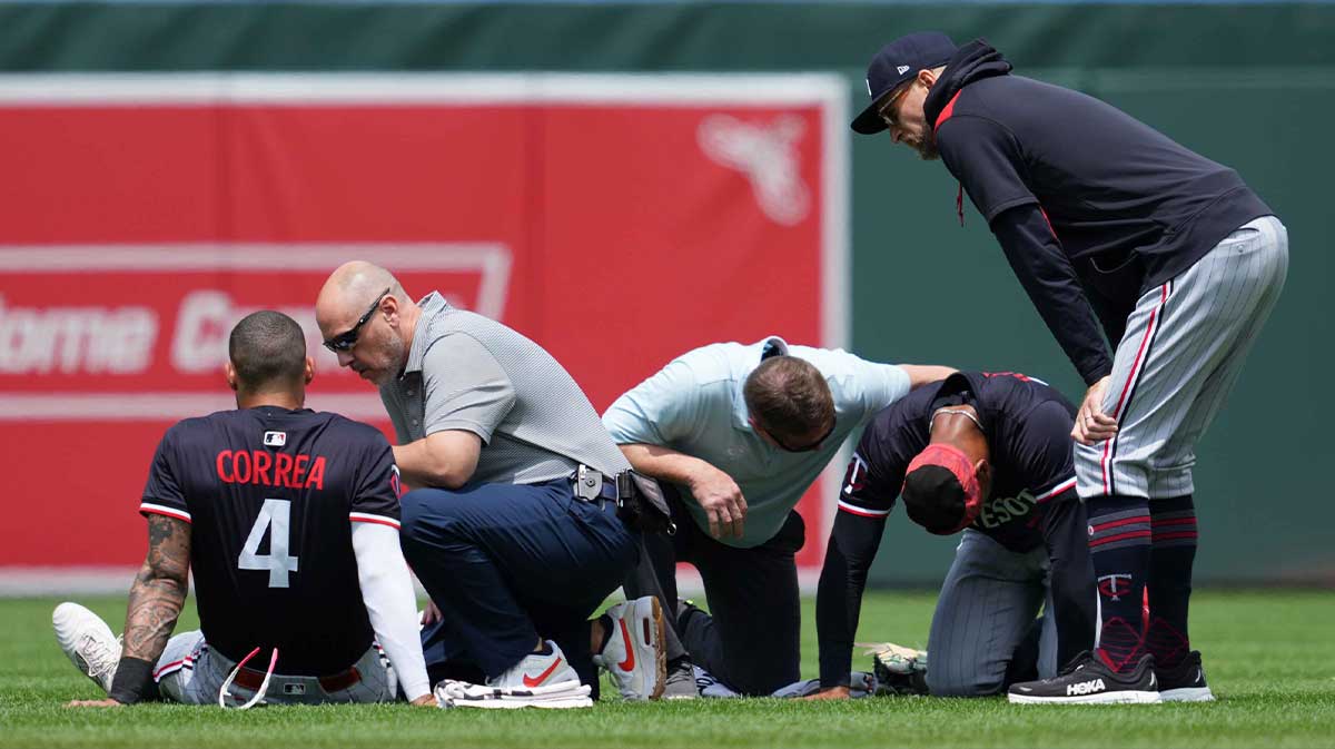 Minnesota Twins outfielder Byron Buxton (25) and shortstop Carlos Correa (4) remain on the ground following a collision while chasing the ball during the third inning against the Baltimore Orioles at Oriole Park at Camden Yards.