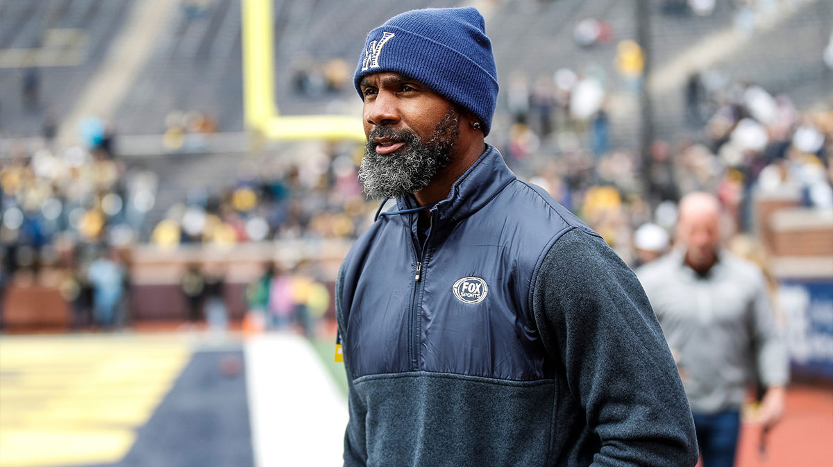Michigan legend Charles Woodson waves at fans during warmup at the spring game at Michigan Stadium
