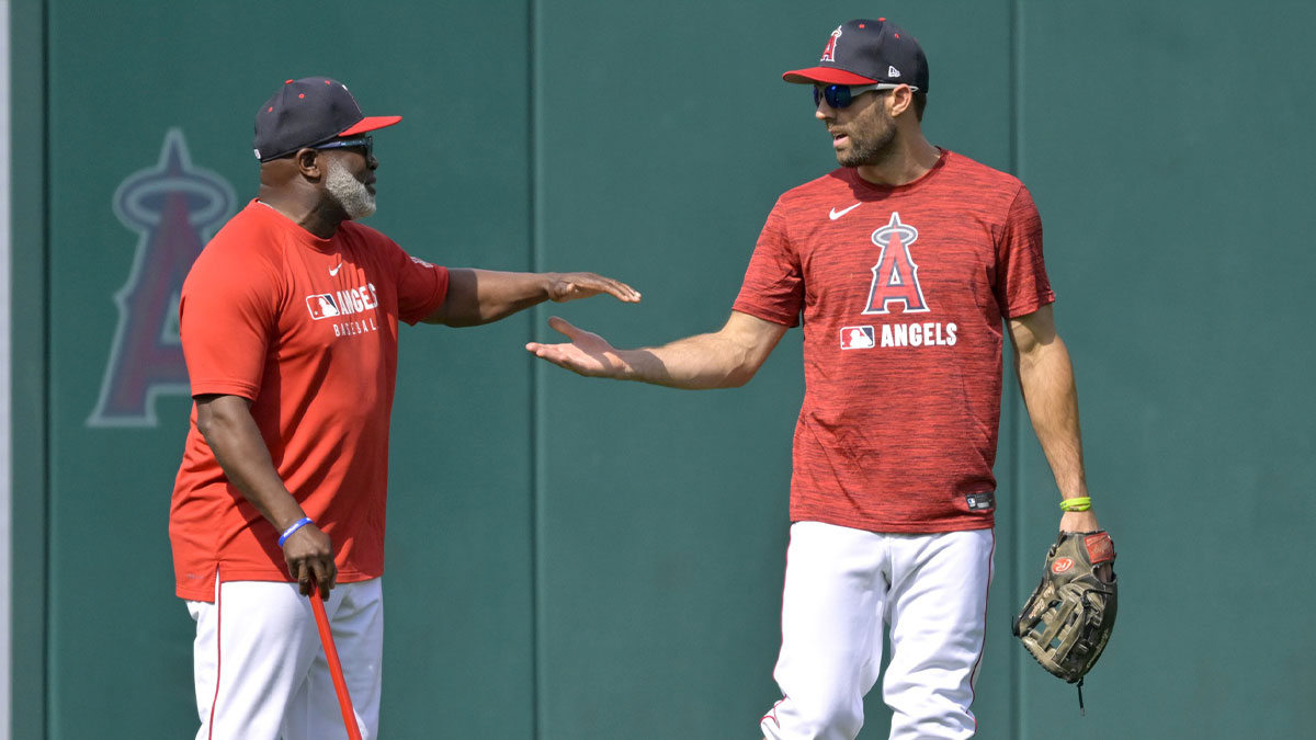 Los Angeles Angels center fielder Chris Taylor (33) is greeted by first base coach Eric Young Sr. (85) in the outfield prior to the game against the New York Yankees.