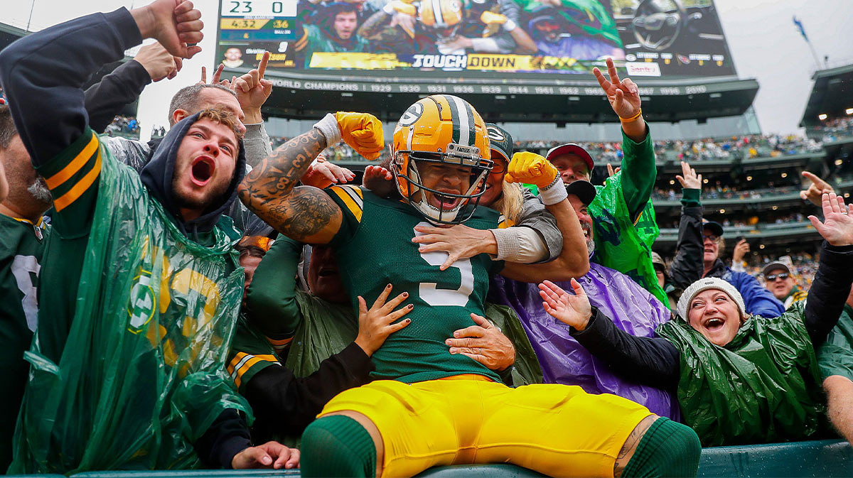 Green Bay Packers wide receiver Christian Watson (9) flexes as he does a “Lambeau Leap” with Packers fans after scoring a touchdown.