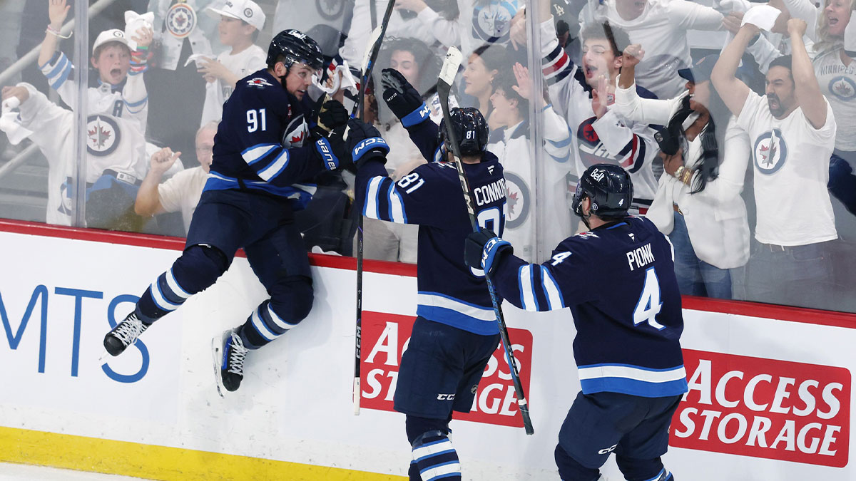 Winnipeg Jets center Cole Perfetti (91) celebrates after his goal against the St. Louis Blues with teammates left wing Kyle Connor (81) and defenseman Neal Pionk (4) in the third period in game seven of the first round of the 2025 Stanley Cup Playoffs at Canada Life Centre