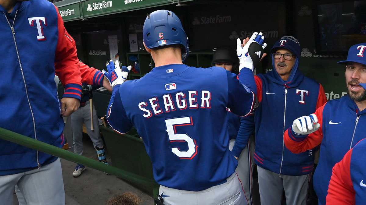 Apr 9, 2025; Chicago, Illinois, USA; Texas Rangers shortstop Corey Seager (5) celebrates his home run with teammates in the dugout during the first inning at Wrigley Field. Mandatory Credit: Patrick Gorski-Imagn Images