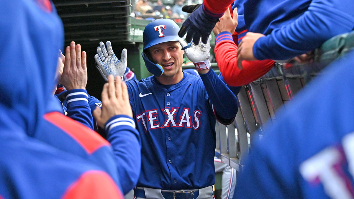 Apr 9, 2025; Chicago, Illinois, USA; Texas Rangers shortstop Corey Seager (5) celebrates with teammates in the dugout after hitting a home run during the seventh inning against the Chicago Cubs at Wrigley Field. Mandatory Credit: Patrick Gorski-Imagn Images