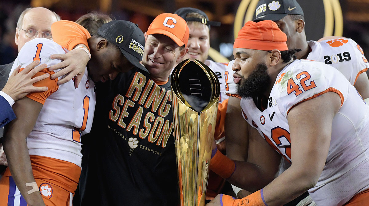 Clemson Tigers head coach Dabo Swinney celebrates with cornerback Trayvon Mullen (1) and defensive lineman Christian Wilkins (42) on the podium with the College Football Playoff National Championship Trophy after defeating the Alabama Crimson Tide in the 2019 College Football Playoff Championship game at Levi's Stadium.