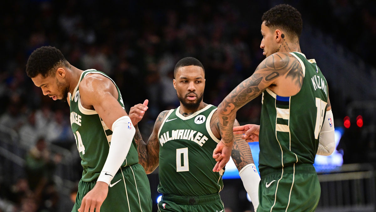 Milwaukee Bucks guard Damian Lillard (0) celebrates a three-point basket with forward Giannis Antetokounmpo (34) and forward Kyle Kuzma (18) in the fourth quarter against the Denver Nuggets at Fiserv Forum.