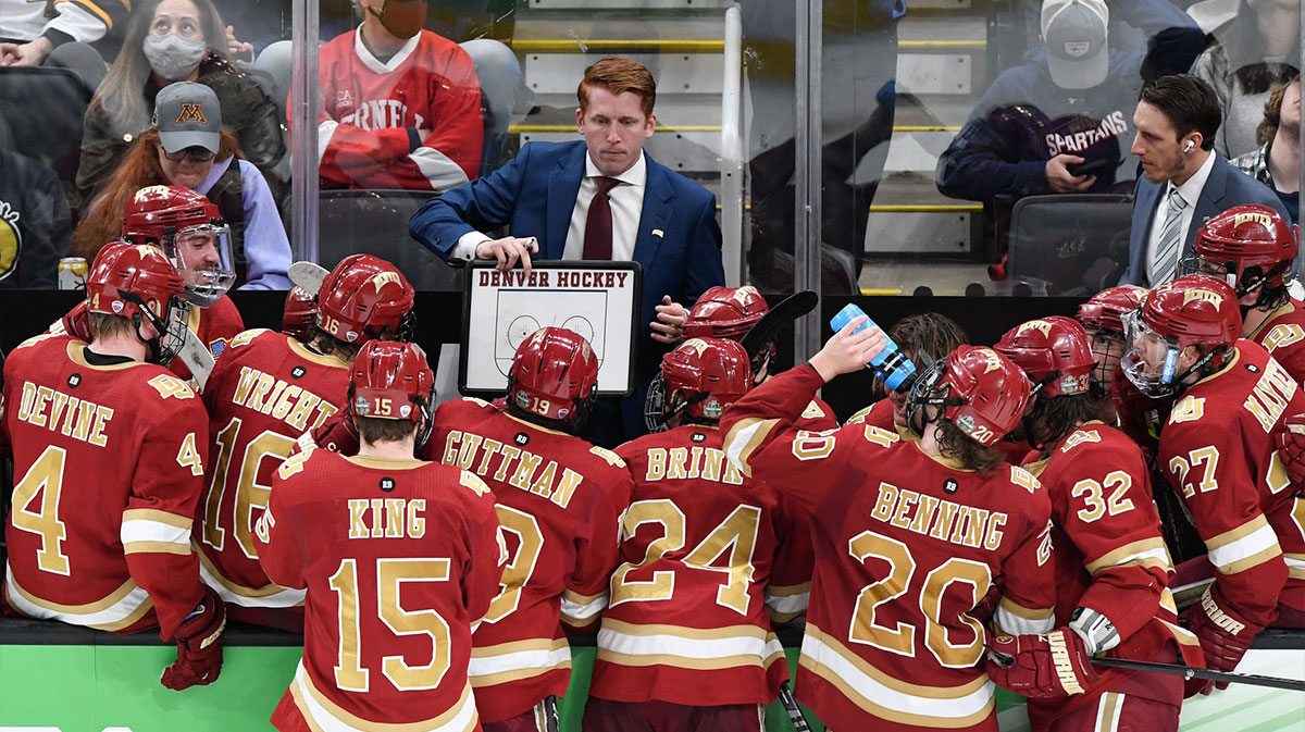 Denver Pioneers head coach David Carle talks with his team during a timeout during the third period of the 2022 Frozen Four college ice hockey national championship game against the Minnesota State Mavericks at TD Garden.