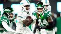 Miami Dolphins running back De'Von Achane (28) scores a touchdown after running past New York Jets cornerback Brandin Echols (26) and New York Jets linebacker Jamien Sherwood (44) in the fourth quarter, Sunday January 5, 2025, in East Rutherford.