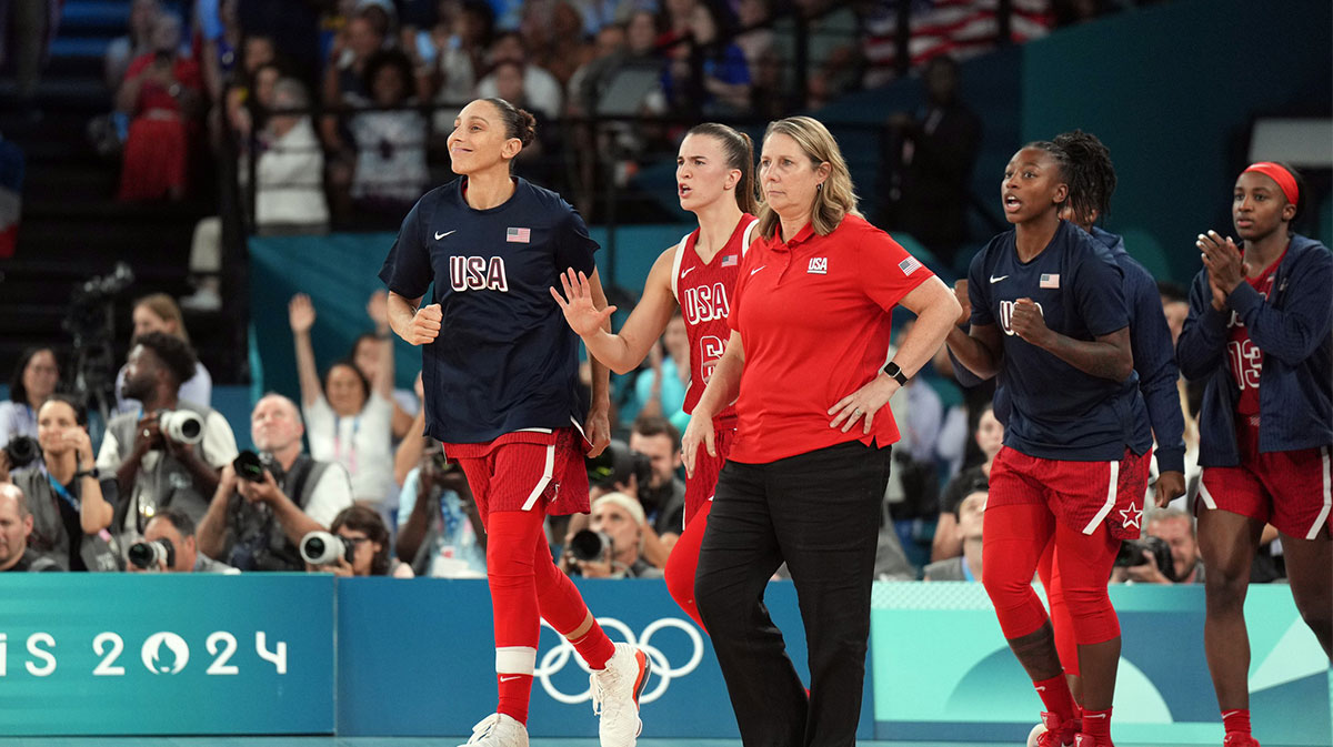 United States shooting guard Diana Taurasi (12) and guard Sabrina Ionescu (6) and head coach Cheryl Reeve react after defeating France in the women's gold medal game during the Paris 2024 Olympic Summer Games at Accor Arena.