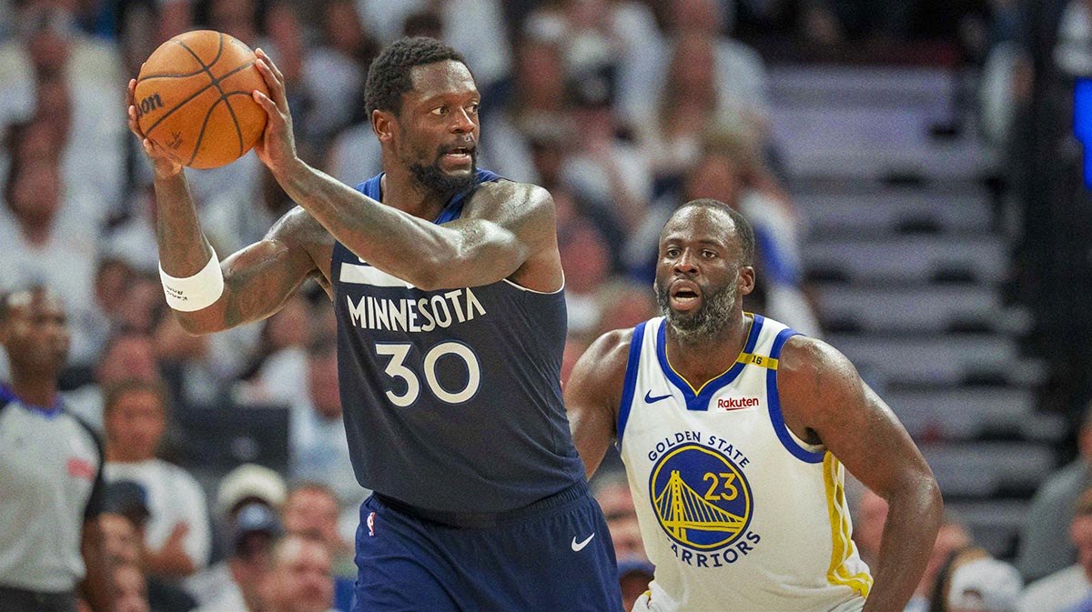 Minnesota Timberwolves forward Julius Randle (30) holds the ball as Golden State Warriors forward Draymond Green (23) plays defense in the second half during game five of the second round for the 2025 NBA Playoffs at Target Center.