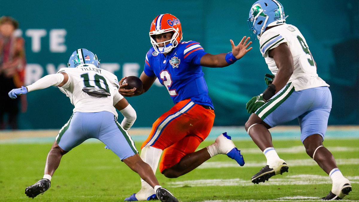 Florida Gators quarterback DJ Lagway (2) eludes Tulane Green Wave defensive back Lu Tillery (10) and Tulane Green Wave linebacker Terrell Allen (9) during the second half at Raymond James Stadium in Tampa, FL on Friday, December 20, 2024 in the 2024 Union Home Mortgage Gasparilla Bowl. The Gators defeated Tulane 33-8.