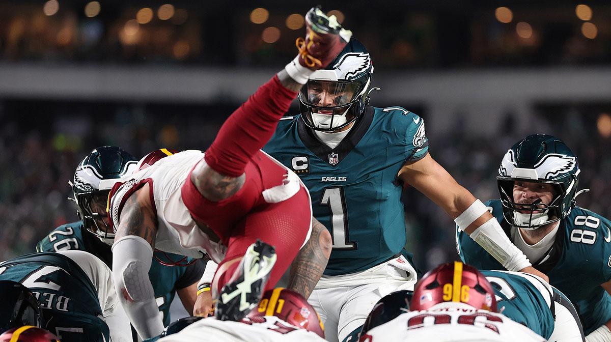 Philadelphia Eagles quarterback Jalen Hurts (1) reacts as Washington Commanders linebacker Frankie Luvu (4) leaps over linemen before a tush push snap during the second half in the NFC Championship game at Lincoln Financial Field.