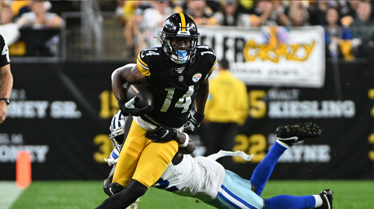 Pittsburgh Steelers wide receiver George Pickens (14) breaks a tackle by Dallas Cowboys cornerback Jourdan Lewis (2) during the first quarter at Acrisure Stadium.