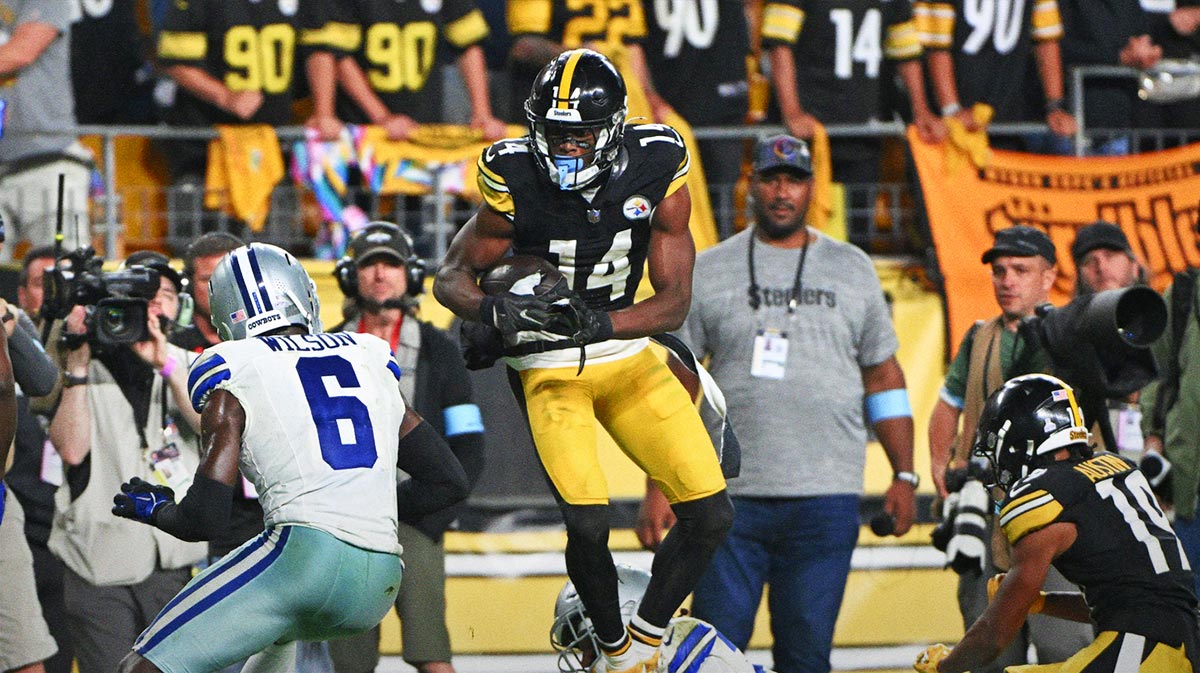 Pittsburgh Steelers wide receiver George Pickens (14) makes a catch in front of Dallas Cowboys safety Donovan Wilson (6) during the fourth quarter at Acrisure Stadium.