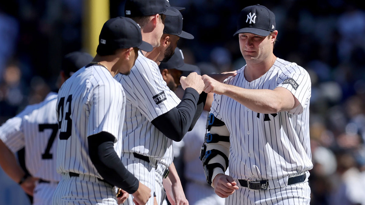 New York Yankees injured starting pitcher Gerrit Cole (45) fist bumps teammates during introductions before an opening day game against the Milwaukee Brewers at Yankee Stadium.