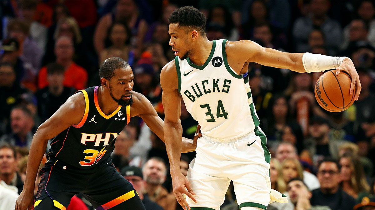 Milwaukee Bucks forward Giannis Antetokounmpo (34) handles the ball against the Phoenix Suns forward Kevin Durant (35) during the third quarter at Footprint Center.
