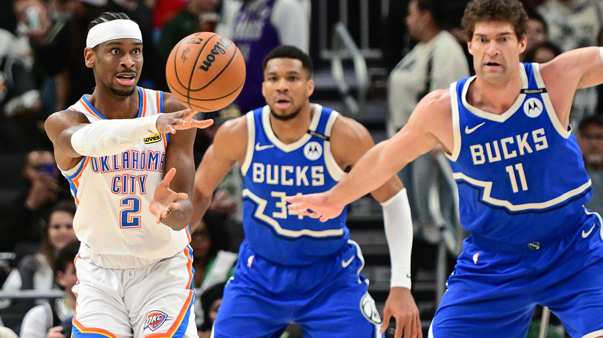 Oklahoma City Thunder guard Shai Gilgeous-Alexander (2) passes the ball away from Milwaukee Bucks forward Giannis Antetokounmpo (34) and center Brook Lopez (11) in the third quarter at Fiserv Forum.