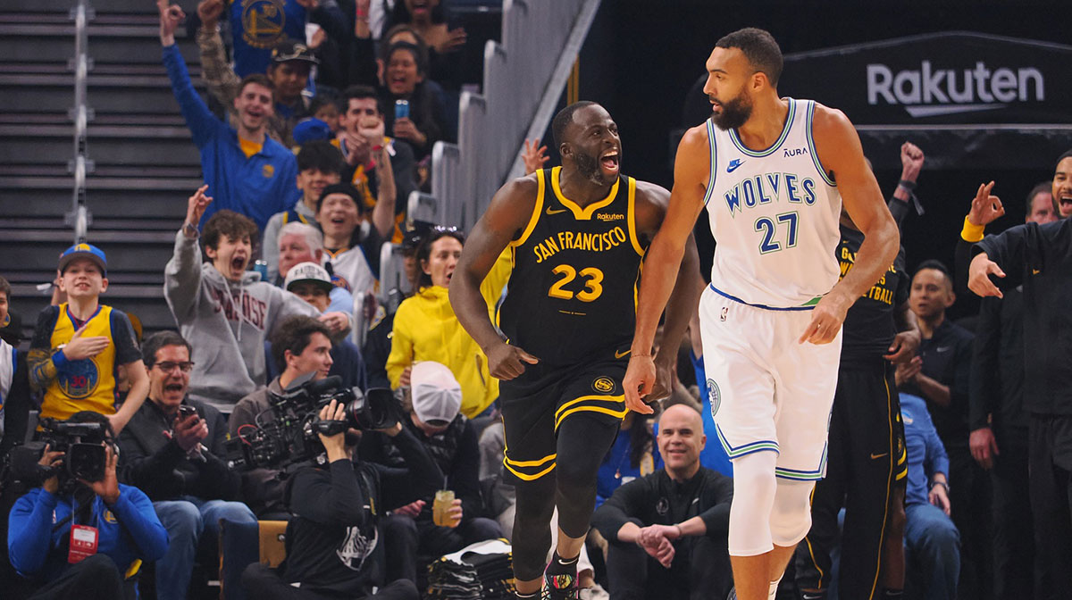 Golden State Warriors forward Draymond Green (23) celebrates behind Minnesota Timberwolves center Rudy Gobert (27) after scoring a three point basket during the first quarter at Chase Center.