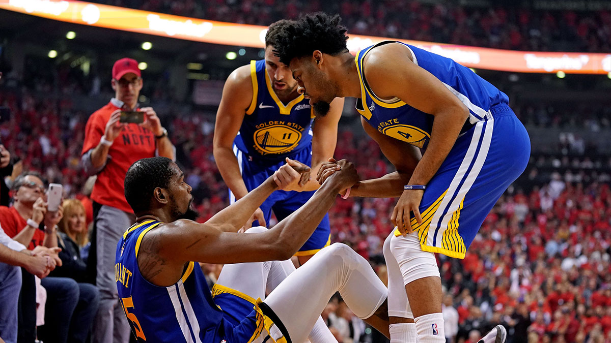 Golden State Warriors forward Kevin Durant (35) is helped up by guard Quinn Cook (4) and guard Klay Thompson (11) after an apparent injury during the second quarter in game five of the 2019 NBA Finals against the Toronto Raptors at Scotiabank Arena.
