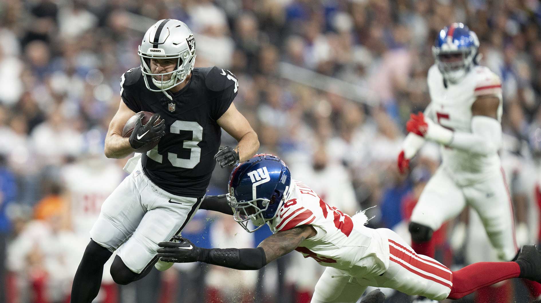 November 5, 2023; Paradise, Nevada, USA; Las Vegas Raiders wide receiver Hunter Renfrow (13) is tackled by New York Giants cornerback Cor'Dale Flott (28) during the second quarter at Allegiant Stadium.