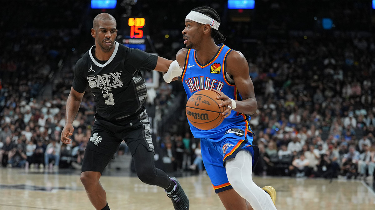 Oklahoma City Thunder guard Shai Gilgeous-Alexander (2) dribbles past San Antonio Spurs guard Chris Paul (3) in the second half at Frost Bank Center.