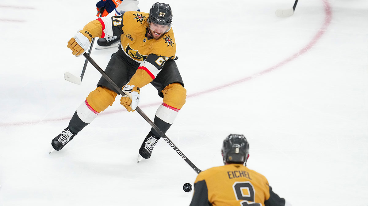 Vegas Golden Knights defenseman Shea Theodore (27) passes the puck to center Jack Eichel (9) during an overtime period of game two of the second round of the 2025 Stanley Cup Playoffs against the Edmonton Oilers at T-Mobile Arena.