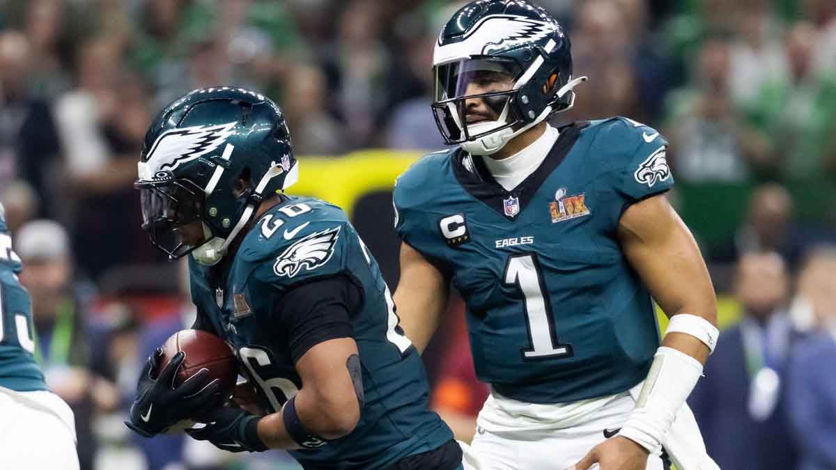Philadelphia Eagles quarterback Jalen Hurts (1) hands the ball off to running back Saquon Barkley (26) against the Kansas City Chiefs during Super Bowl LIX at Ceasars Superdome.
