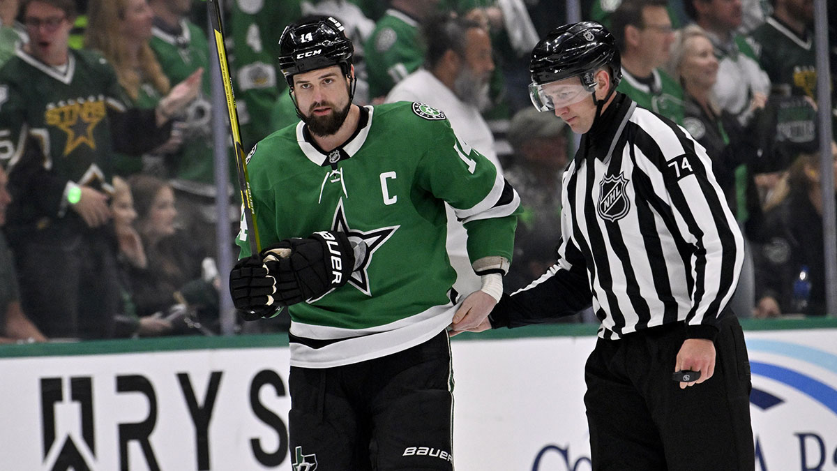 Dallas Stars left wing Jamie Benn (14) is led off the ice by linesman Trent Knorr (74) after receiving a roughing penalty against the Winnipeg Jets during the third period in game four of the second round of the 2025 Stanley Cup Playoffs at American Airlines Center.