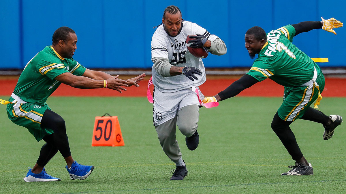 Former Green Bay Packers running back Ryan Grant (25) slips past former Packers running back Ahman Green, left, and former Packers wide receiver Chris Francies (7) during the Gridiron Greats Celebrity Flag Football Game on Sunday, April 27, 2025, at Capital Credit Union Park in Ashwaubenon, Wisconsin.