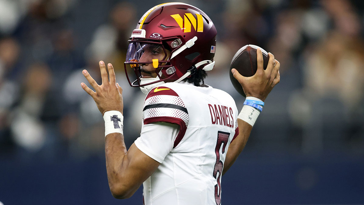 Washington Commanders quarterback Jayden Daniels (5) throws a pass against the Dallas Cowboys during the first quarter at AT&T Stadium.