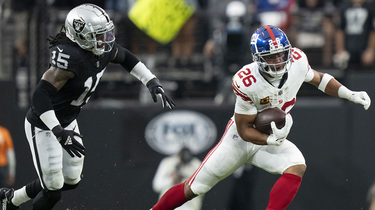 New York Giants running back Saquon Barkley (26) runs the football against Las Vegas Raiders linebacker Jaylon Smith (15) during the first quarter at Allegiant Stadium.