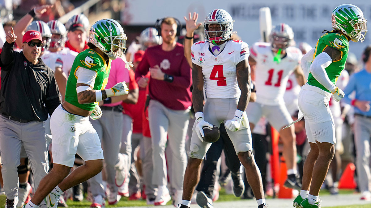 Ohio State Buckeyes wide receiver Jeremiah Smith (4) celeb rates a first down catch beside Oregon Ducks defensive back Kobe Savage (5) during the first half of the College Football Playoff quarterfinal at the Rose Bowl