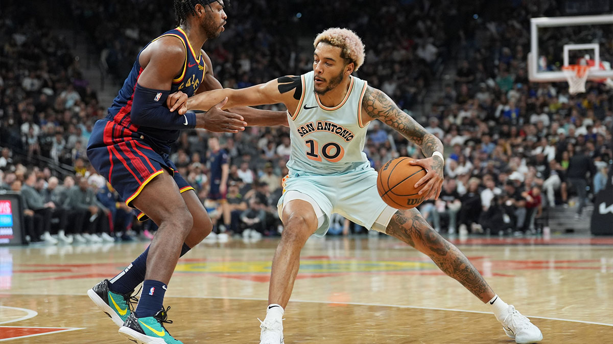 San Antonio Spurs forward Jeremy Sochan (10) dribbles against Golden State Warriors guard Buddy Hield (7) in the second half at Frost Bank Center.