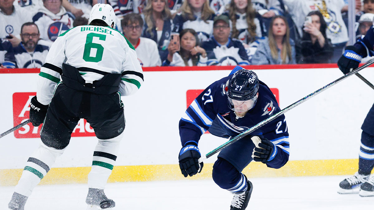 Winnipeg Jets forward Nikolaj Ehlers (27) is checked by Dallas Stars defenseman Liam Bichsel (6) during the second period in game one of the second round of the 2025 Stanley Cup Playoffs at Canada Life Centre.