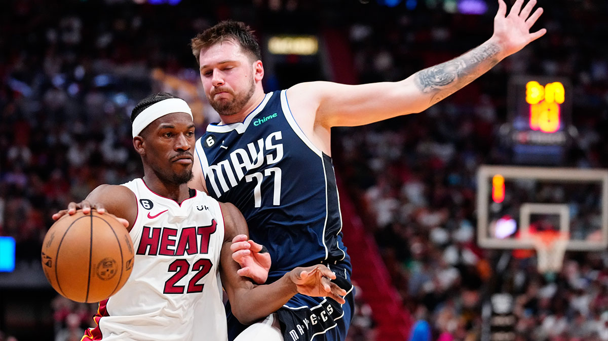 Miami Heat forward Jimmy Butler (22) dribbles the ball past Dallas Mavericks guard Luka Doncic (77) during the second quarter at Miami-Dade Arena.
