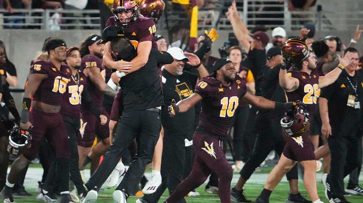 Arizona State Sun Devils quarterback Sam Leavitt (10) jumps into the arms of head coach Kenny Dillingham after the the Sun Devils upset the (16) Utah Utes 27-19 at Mountain America Stadium.
