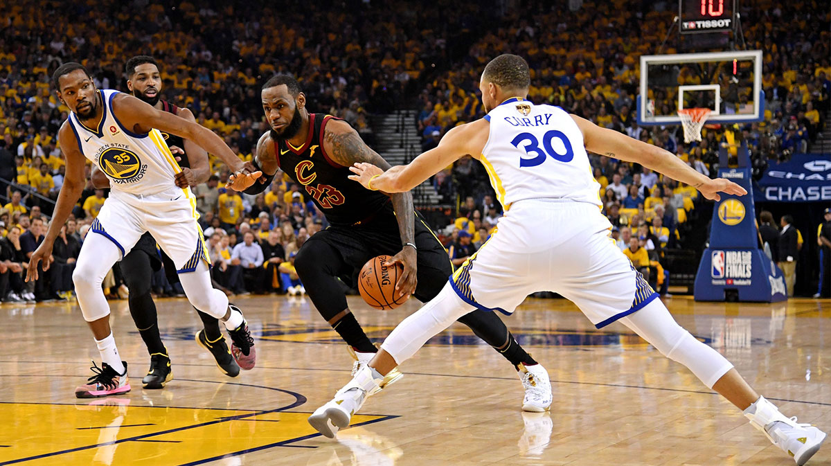 Cleveland Cavaliers forward LeBron James (23) drives to the basket against Golden State Warriors guard Stephen Curry (30) and forward Kevin Durant (35) during the first quarter in game one of the 2018 NBA Finals at Oracle Arena.