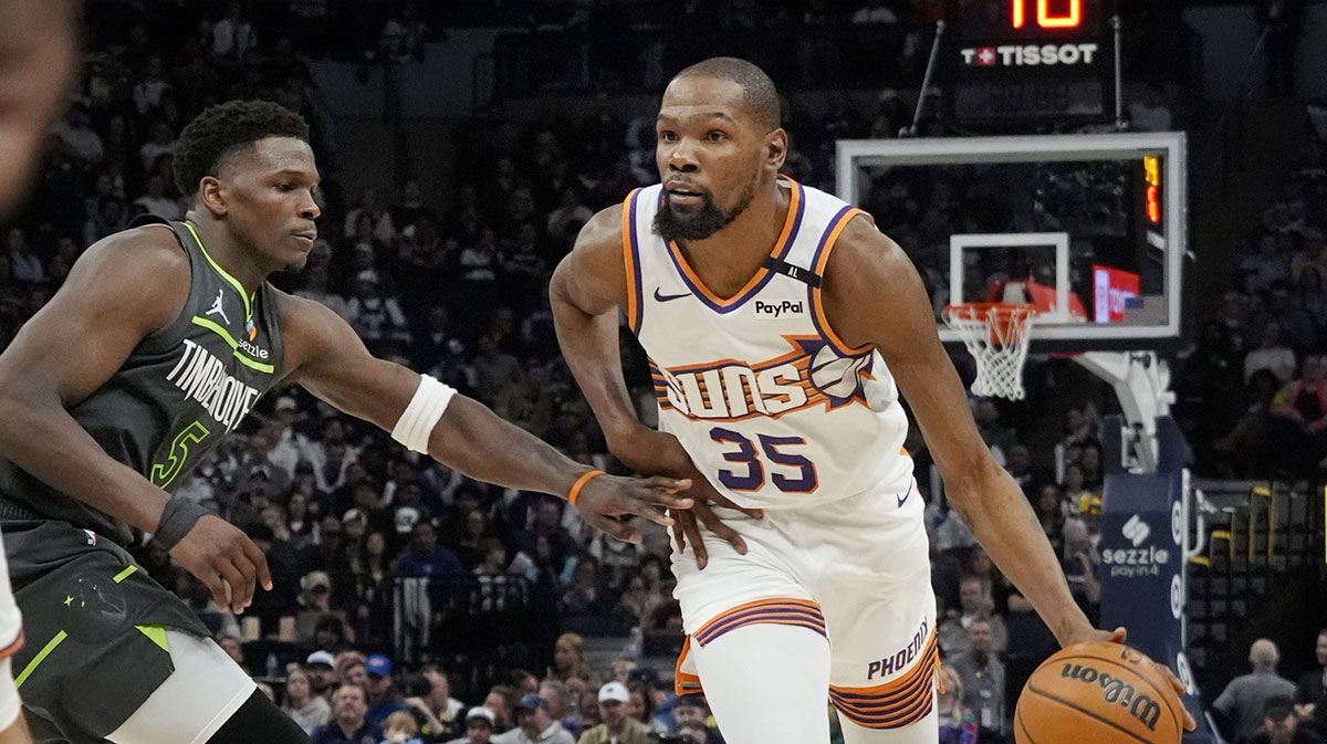 Phoenix Suns forward Kevin Durant (35) brings the ball up as Minnesota Timberwolves guard Anthony Edwards (5) defends him in the fourth quarter at Target Center.