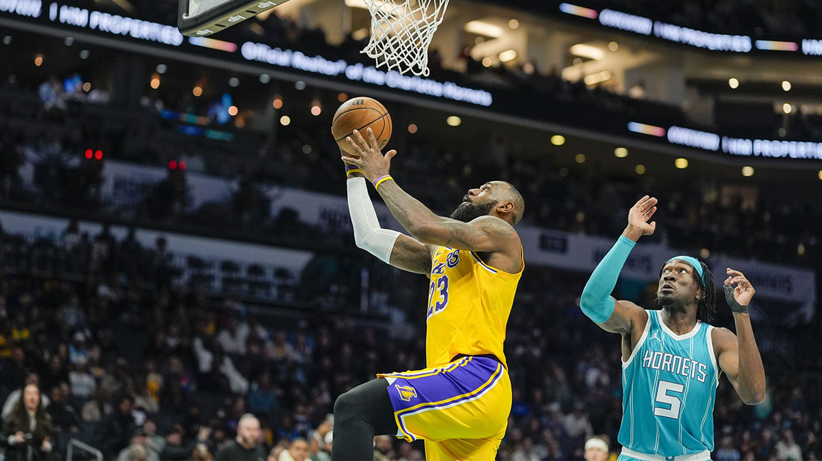 Lakers forward LeBron James (23) makes a layup past Charlotte Hornets center Mark Williams (5)