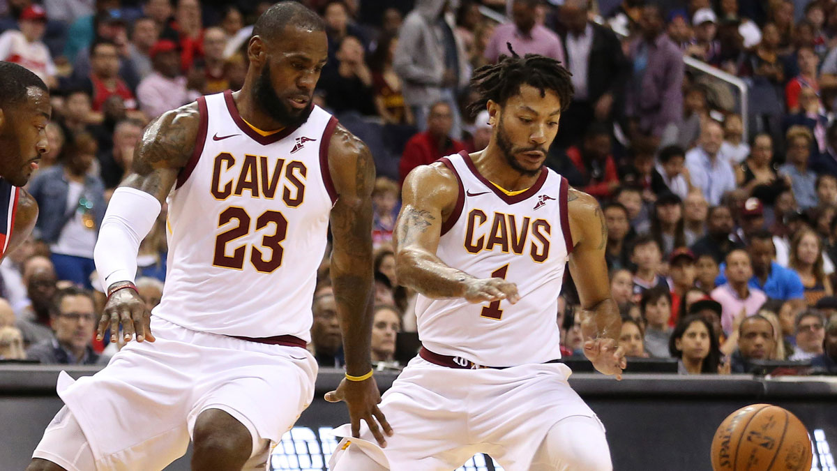Cleveland Cavaliers forward LeBron James (23) and Cavaliers guard Derrick Rose (1) reach for a loose ball against the Washington Wizards at Capital One Arena.