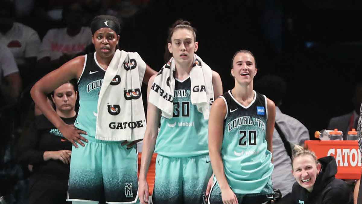 New York Liberty forwards Jonquel Jones (35) and Breanna Stewart (30) and guard Sabrina Ionescu (20) watch the game from the bench in the fourth quarter against the Las Vegas Aces at Barclays Center.