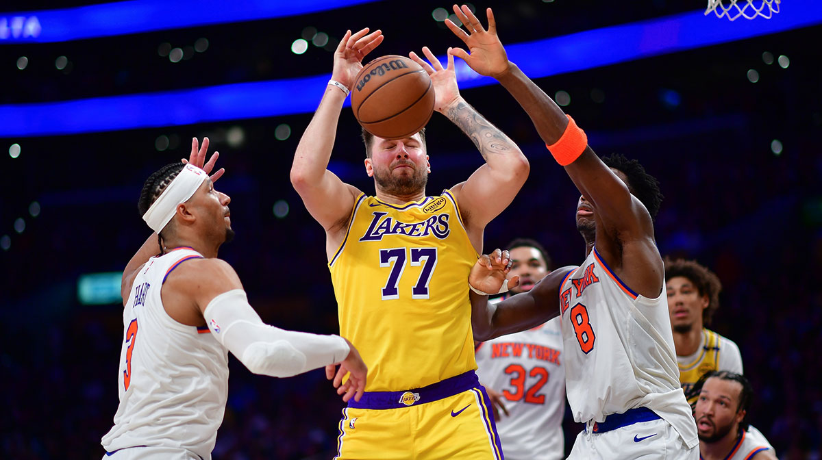 New York Knicks guard Josh Hart (3) and forward OG Anunoby (8) play for the ball against Los Angeles Lakers guard Luka Doncic (77) during the second half at Crypto.com Arena.