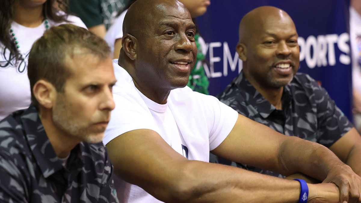 Former professional basketball player and Michigan State alumni, Earving “Magic” Johnson, center, watches the Colorado Buffaloes take on the Michigan State Spartans in the first half of an NCAA college basketball game at Lahaina Civic Center.