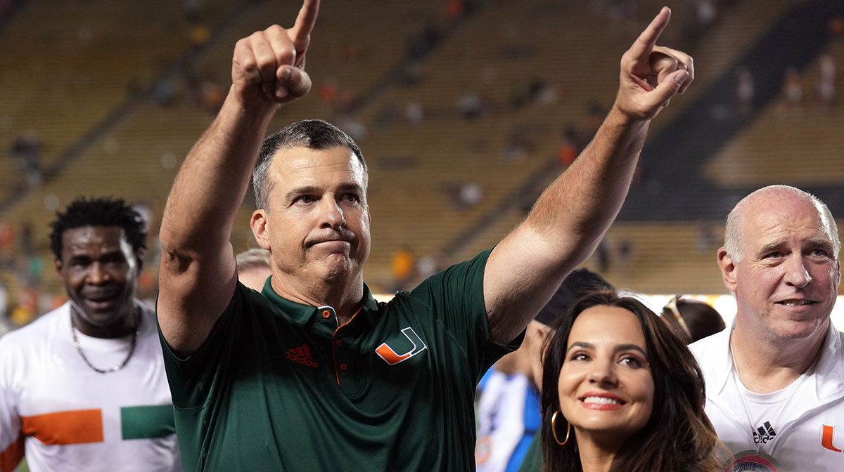 Miami Hurricanes head coach Mario Cristobal (center left) gestures to fans with wife Jessica (center right) after defeating the California Golden Bears at California Memorial Stadium.