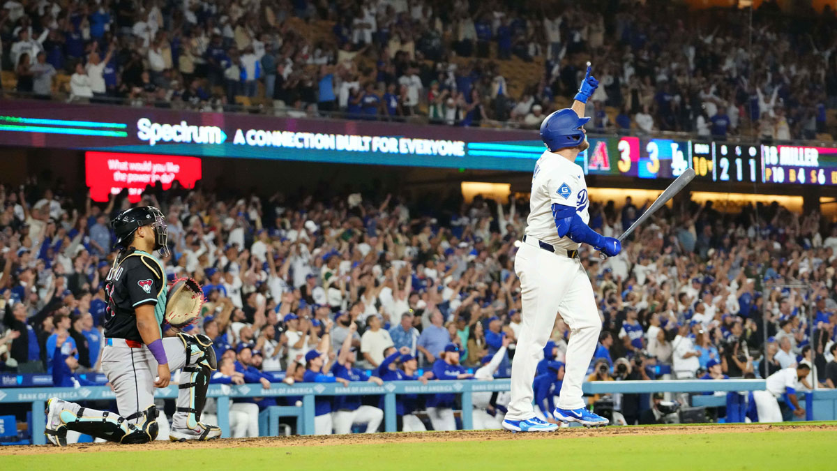 Los Angeles Dodgers third baseman Max Muncy (13) hits a walk-off sacrifice fly in the 10th inning as Arizona Diamondbacks catcher Gabriel Moreno (14) and home plate umpire Edwin Moscoso watches at Dodger Stadium.