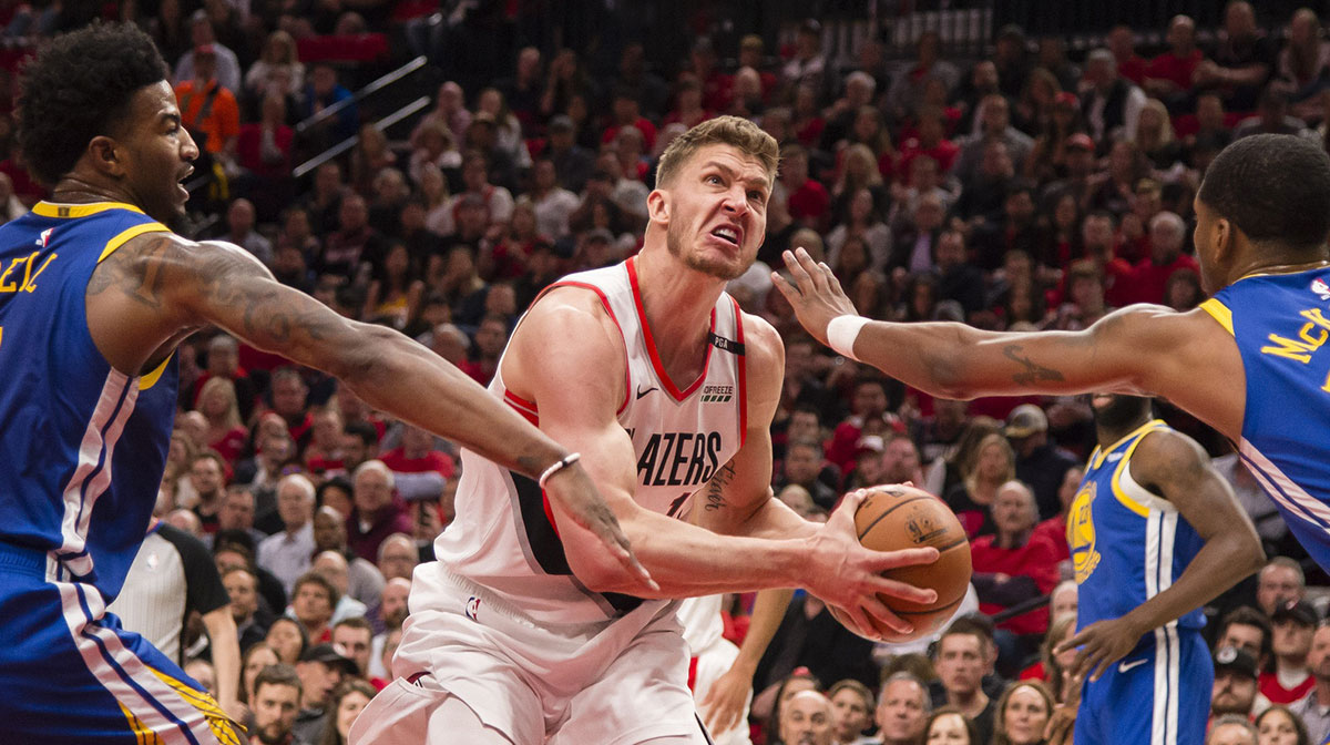 Portland Trail Blazers forward Meyers Leonard (11) drives to the basket against Golden State Warriors forward Jordan Bell (2) and forward Alfonzo McKinnie (28) during the first half in game four of the Western conference finals of the 2019 NBA Playoffs at Moda Center.